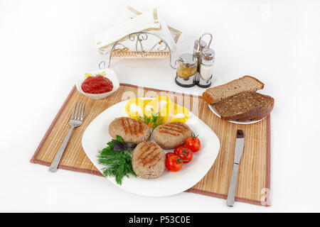 Koteletts mit grünen, Tomaten und Gurken. Mit schwarzen oder weißen Brot und einem Glas Rotwein servieren. Eine perfekte Ergänzung ist eine heiße Soße und Senf. T Stockfoto