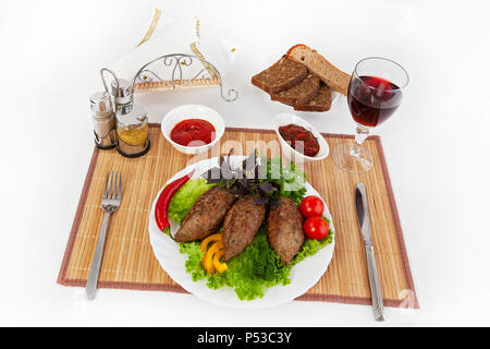 Koteletts mit grünen, Tomaten und Gurken. Mit schwarzen oder weißen Brot und einem Glas Rotwein servieren. Eine perfekte Ergänzung ist eine heiße Soße und Senf. T Stockfoto