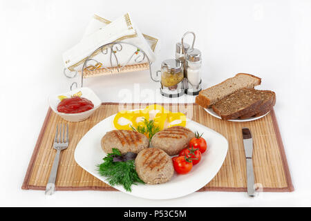 Koteletts mit grünen, Tomaten und Gurken. Mit schwarzen oder weißen Brot und einem Glas Rotwein servieren. Eine perfekte Ergänzung ist eine heiße Soße und Senf. T Stockfoto