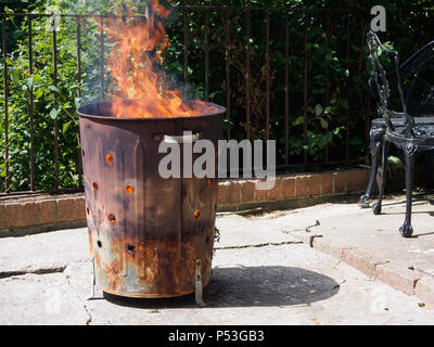 Zerstörung von Abfall durch Verbrennen in einem Garten Verbrennungsanlage bin. Ursache Rauch, die Luftverschmutzung. Nicht die Umwelt. Stockfoto