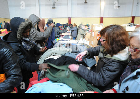 Februar 21, 2015 - Calais, Frankreich: Ein französischer Christliche NGO verteilt warme Kleidung für Migranten leben in Hütten, wie sie für eine Gelegenheit, nach Großbritannien zu warten. Die Migranten, die meist aus Erythrea, Äthiopien, Afghanistan, Syrien und Sudan kommen versuchen ihr Glück jede Nacht von Diskret boarding Lkw über die Fähre oder Eurotunnel nach England ein. Verteilung de chauds vetements les Migranten gießen Stockfoto