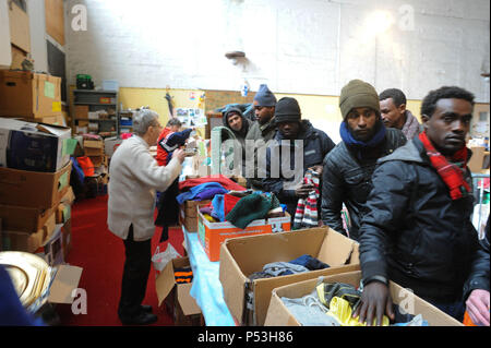 Februar 21, 2015 - Calais, Frankreich: Ein französischer Christliche NGO verteilt warme Kleidung für Migranten leben in Hütten, wie sie für eine Gelegenheit, nach Großbritannien zu warten. Die Migranten, die meist aus Erythrea, Äthiopien, Afghanistan, Syrien und Sudan kommen versuchen ihr Glück jede Nacht von Diskret boarding Lkw über die Fähre oder Eurotunnel nach England ein. Verteilung de chauds vetements les Migranten gießen Stockfoto