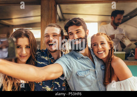 Hübscher junger Mann unter selfie mit Freunden. Gruppe von Männern und Frauen, die selfie im Summer Festival. Stockfoto
