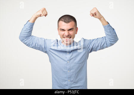 Portrait von sehr jungen Hispanic Mann, feiert Sieg mit erhobenen Händen und Schreien, seine Fußball-Team gewinnen Stockfoto