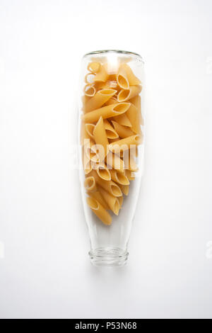 Penne Rigate Pasta in Glasfläschchen auf weißem Hintergrund aus einem hohen Winkel anzeigen isoliert Stockfoto