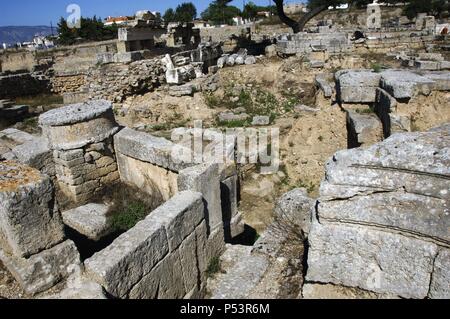 ARTE GRIEGO. GRECIA. RUINAS DE CORINTO. Vista parcial del yacimiento Arqueológico. Las mejores del MURO DE LOS TRIGLIFOS oculta que la Entrada a una FUENTE SAGRADA que formaba Parte de un antiguo Lugar de culto. Estado de Korinthia. Región del Peloponeso. Stockfoto