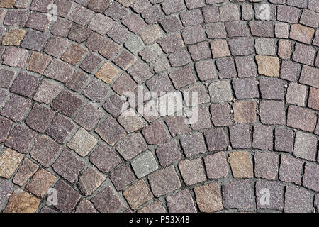 Dekorative Stein Kopfsteinpflaster gelegt, im Freien in einem kreisförmigen Muster von oben als full frame Textur und Muster gesehen Stockfoto