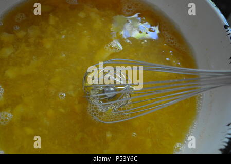 Essen, hausgemachte Mahlzeiten kochen, gekochte Pfirsichscheiben, Pfirsichkompott mit Gelatine und Metallquirl. Herstellung von Pfirsichgelee aus natürlichen Früchten. Stockfoto