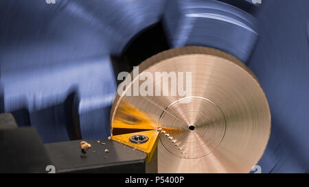 Detail eines Werkzeug bit beim Drehen auf einer Drehbank. Künstlerische industriellen Hintergrund. Bronze Produkt in Maschine Spannfutter gespannt. Späne, gelb Werkzeug, Werkstück. Stockfoto