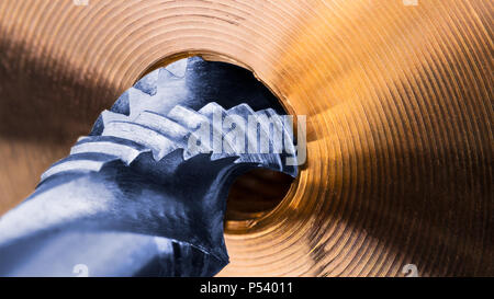 Spiralnut tippen. Detail der goldenen Metall teil. Künstlerische close-up von Blue Steel Schneidwerkzeug für Threading. Bronze Werkstück. Engineering Hintergrund. Stockfoto