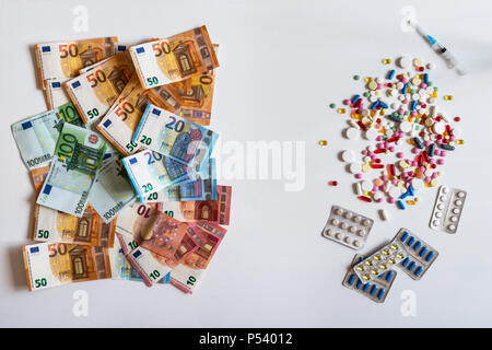 Geld und Pillen. Pillen in verschiedenen Farben auf weißem Hintergrund. Stockfoto