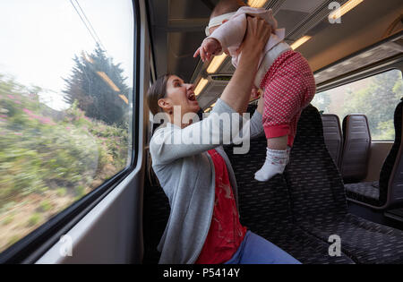 Junge Mutter Reisen mit Baby Mädchen im Zug Stockfoto