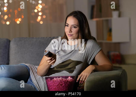 Frau Fernsehen in der Nacht auf einer Couch im Wohnzimmer zu Hause sitzen Stockfoto