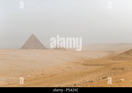 Die Wüste Landschaft bei Menkaure Pyramide (links), und drei kleine "Queen's Pyramiden in Gizeh, Ägypten. Stockfoto