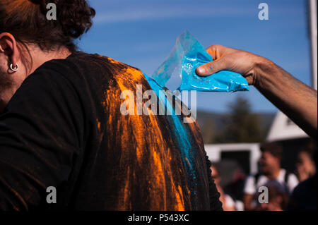 Gießen farbigen Pulver Farbe zu einem schwarzen Shirts Mann an der Farben Festival in Izmir Buca Golet. Stockfoto