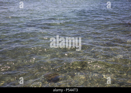 Transparente und klare Meer bei Zypern Insel. Kristallklares Wasser mit Kieselsteinen und Reflexion von Sun Hintergrund. Stockfoto