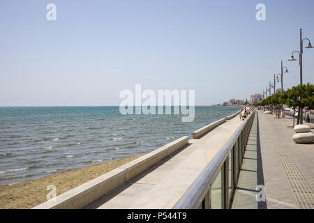 Zypern, Larnaca. Stein Pfad für die Promenade rund um das Meer. Hafen, Strand, Gebäude, blauer Himmel. Stockfoto