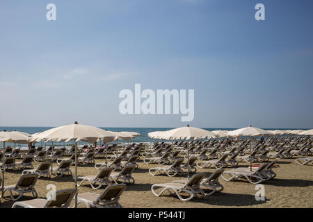 Mackenzie Sandstrand in Larnaca, Zypern. Liegestühle und Sonnenschirme neben Meer. Blauer Himmel Hintergrund, Detailansicht. Stockfoto