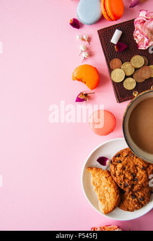 Flach der femenine Dinge Cookies/Perlen Blumen auf einem pknk Hintergrund. Ansicht von oben. Stockfoto