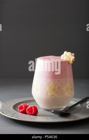 Gesunde layered Himbeere Banane Smoothie in Glas Stockfoto