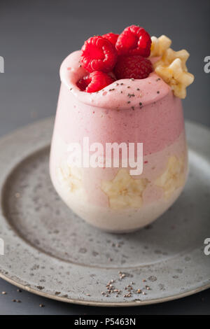 Gesunde layered Himbeere Banane Smoothie in Glas Stockfoto