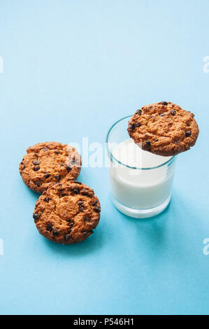 Cookies mit einem Glas Milch auf einem hellblauen Hintergrund. Stockfoto