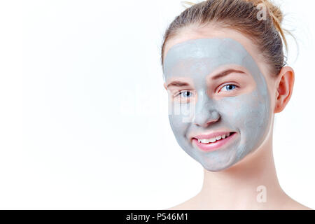 Teenage skincare Konzept. Lächelnde junge rothaarige Mädchen mit getrocknetem Lehm Gesichtsmaske Porträt, auf weißem Hintergrund mit Kopie Raum isoliert. Stockfoto