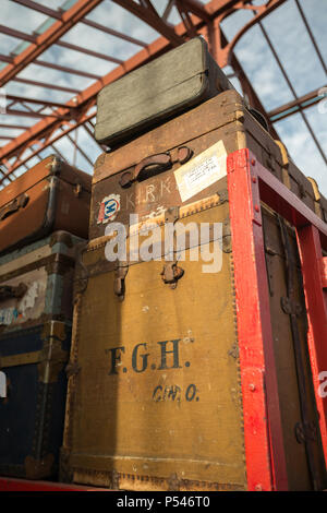 Niedrigen Winkel, vintage Gepäck auf dem Trolley im Vintage UK Bahnhof am Severn Valley Railway heritage Linie übereinander gestapelt für 1940 s WWII Ereignis. Stockfoto