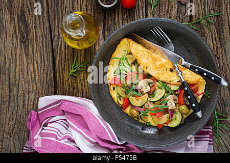 Omelett mit Tomaten, Zucchini und Pilzen. Omelette Frühstück. Gesundes Essen. Ansicht von oben. Flach Stockfoto