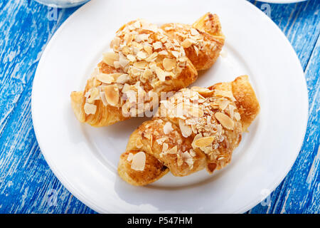 Frische Backwaren. Croissants mit mandelflocken. Traditionelles französisches Frühstück Stockfoto