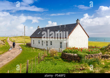 Eine isolierte weiß getünchten Häuschen mit Anzeige der Frühling Blumen auf den Hebriden Insel Iona, Argyll und Bute, Schottland, Großbritannien Stockfoto