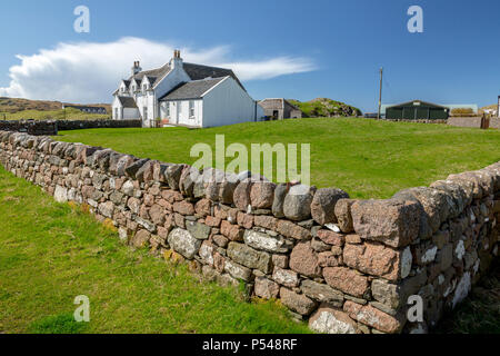 Eine isolierte weiß getünchten Häuschen innerhalb einer trockenmauern Granit Stadtmauer auf der Hebriden Insel Iona, Argyll und Bute, Schottland, Großbritannien Stockfoto