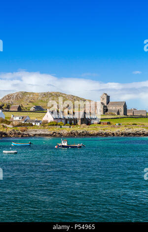 Eine Sammlung von kleinen Fischerbooten in Baile Mor zusammen mit der Abteikirche auf der Hebriden Insel Iona, Argyll und Bute, Schottland, Großbritannien Stockfoto