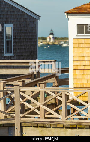 Eine Fernsicht auf Brant Point Leuchtturm zwischen Waterfront Cottages auf alten North Wharf in Nantucket, Massachusetts. Stockfoto