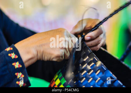 Nahaufnahme der Hand des Weber während des Weben Korb aus Kunststoff hergestellt. Weaver ist weben Kunststoff Warenkorb zeigen bei der Tourist in Bangkok, Thailand. Stockfoto