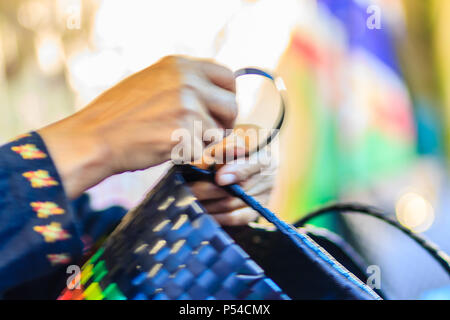 Nahaufnahme der Hand des Weber während des Weben Korb aus Kunststoff hergestellt. Weaver ist weben Kunststoff Warenkorb zeigen bei der Tourist in Bangkok, Thailand. Stockfoto
