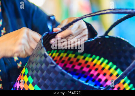 Nahaufnahme der Hand des Weber während des Weben Korb aus Kunststoff hergestellt. Weaver ist weben Kunststoff Warenkorb zeigen bei der Tourist in Bangkok, Thailand. Stockfoto