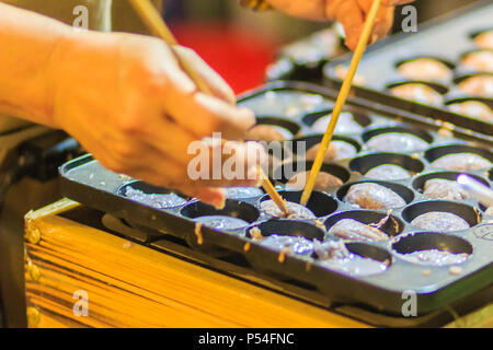 Anbieter ist das Kochen für Khanom khrok oder Kokos - Reis Pfannkuchen, einer der alten Thai Desserts. Stockfoto