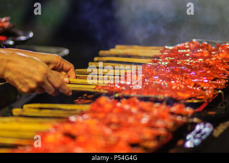 Close up Anbieter während des Grillens Südlichen spicy Chicken. 'Kor Lae" gegrilltes Huhn ist beliebt in Nakhon Sri Thammarat, im Süden von Thailand, wenig Stockfoto