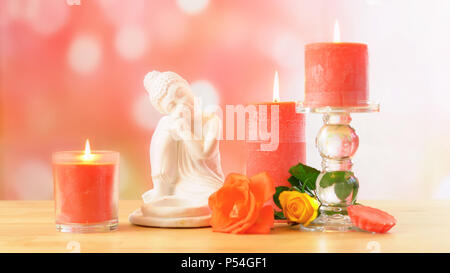 Zen style Aromatherapy Spa Tabelle Einstellung mit Buddha, Blumen und Beleuchtung parfümierte Kerzen in wunderschönen Pastelltönen bokeh. Stockfoto