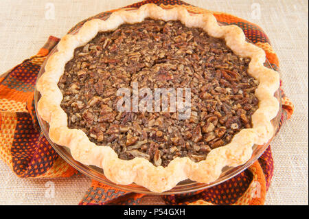 In der Nähe einer ganzen Thanksgiving Pecan Pie auf beigen Hintergrund Stockfoto