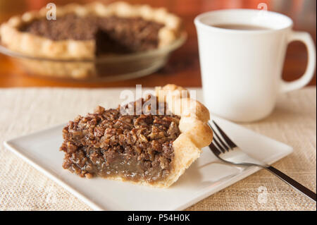 Schicht von Pecan Pie ein weißes Schild mit Tasse Kaffee Stockfoto