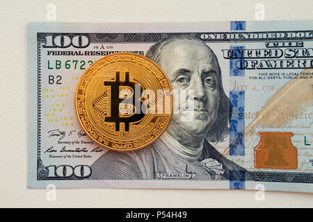 Bitcoin auf 100 Dollar bill Hintergrund, Gold Münze von bitcoin auf hundert Dollar Bill. Das Ergebnis auf cryptocurrency Bergbau. Stockfoto