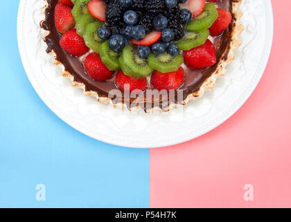 Die Hälfte eines weißen Porzellan Teller mit frischem Sommer Obstkuchen, Erdbeeren, Kiwis, Blaubeeren, boysenberries, Brombeeren. Ansicht von oben flach auf die Hälfte Stockfoto