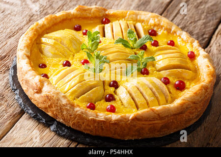 Puffed Apple Cranberry Kuchen mit Pudding und Minze Nahaufnahme auf dem Tisch. Horizontale Stockfoto