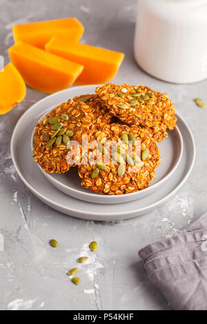 Vegan natürliche Haferflocken pumpkin Cookies auf eine graue Platte, halloween Essen, Herbst essen, veganes Essen Konzept. Stockfoto