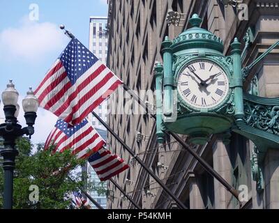 Marshall Field's Uhr über amerikanische Flaggen an der State Street in Chicago, USA Stockfoto