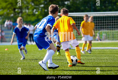 Football-Spieler läuft mit dem Ball auf dem Spielfeld. Fußballer treten Fußballspiel auf dem Spielfeld. Junge Teen Fußballspiel. Jugend-Sport-Hintergrund Stockfoto