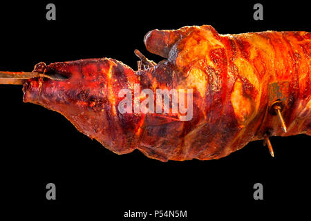 Pork barbecue Landschaft, die einen Braten Spanferkel am Spieß in Schwarz isoliert zurück Stockfoto