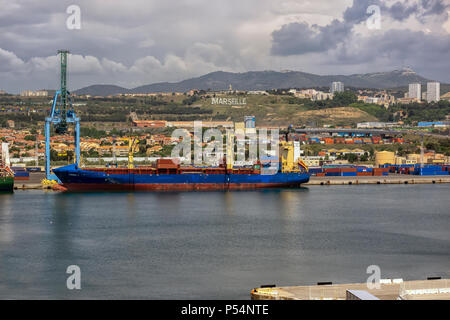 MARSEILLE, FRANKREICH - 18. MAI 2018: Containerschiff im Hafen von Marseille mit der Stadt im Hintergrund Stockfoto